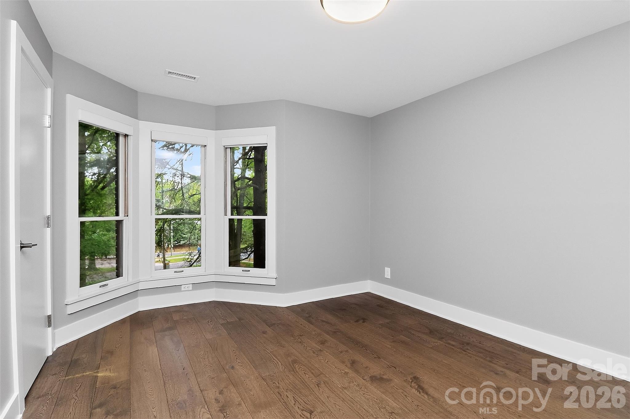 603 Queens Road, Unit B Charlotte, NC 28207 - Photo 20 of 33 a view of an empty room with wooden floor and a window