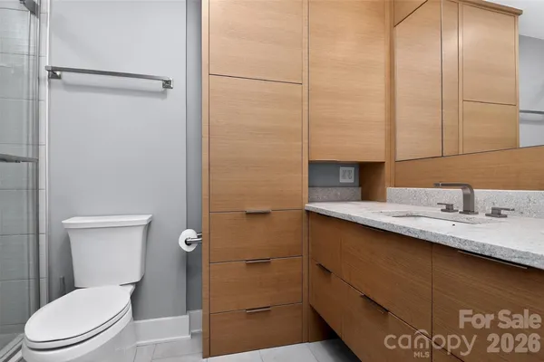 a bathroom with a granite countertop sink toilet and shower