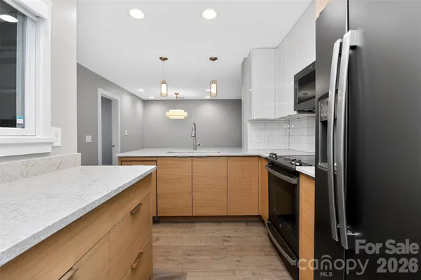 a kitchen with granite countertop a sink stove and refrigerator