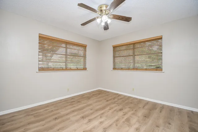 a view of a room with wooden floor and windows