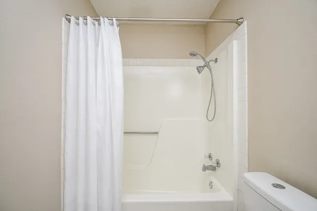 a bathroom with a shower curtain and a bath tub