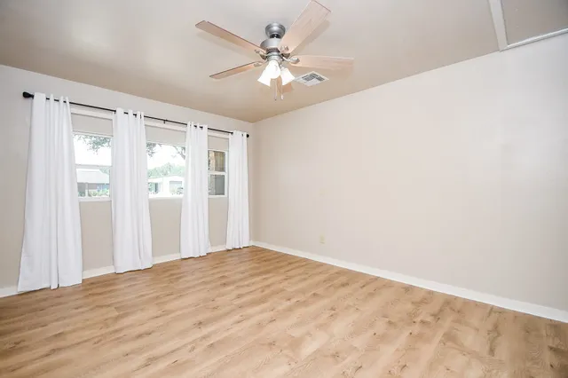 a view of empty room with a ceiling fan and a window