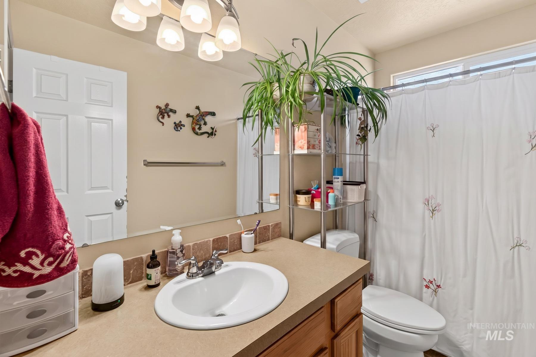 5020 Northrup Way Caldwell, ID 83607 - Photo 27 of 36 Bathroom vanity with an integrated sink and chrome faucet, set against a full-width mirror