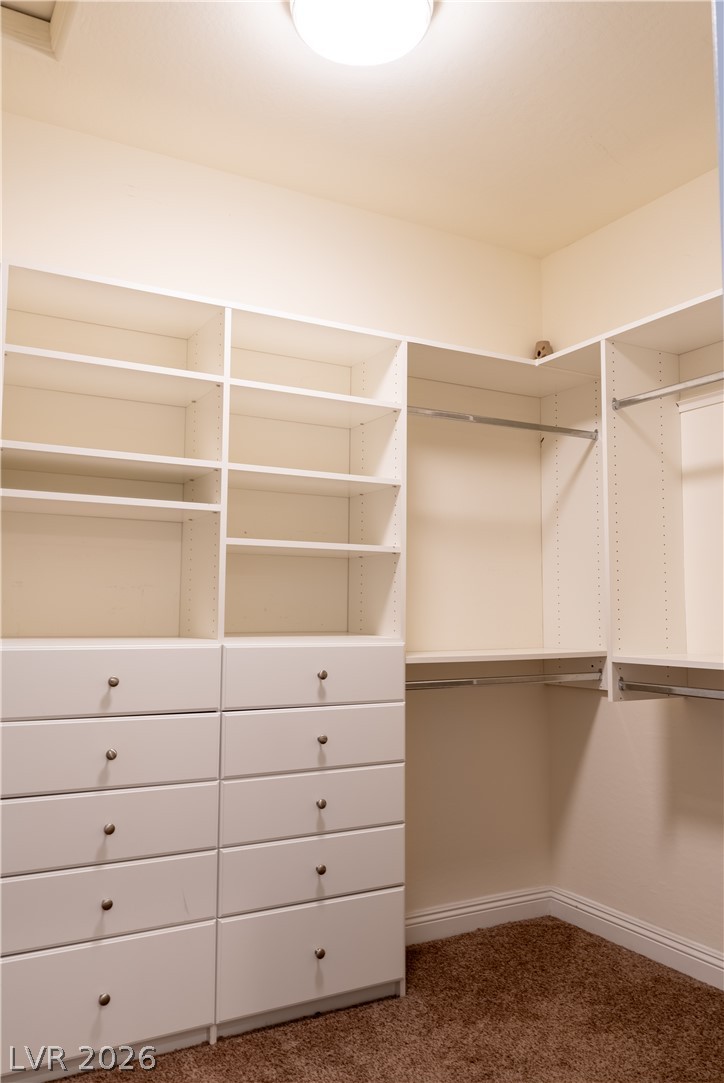 11045 Elk Sands Road Las Vegas, NV 89179 - Photo 30 of 67 Custom built-in shelving and ample drawer storage maximize space in this carpeted walk-in closet.