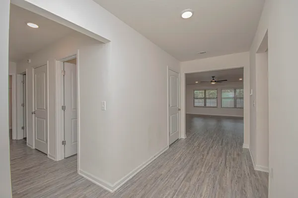 a kitchen with stainless steel appliances granite countertop a sink a stove a refrigerator and island with wooden floor