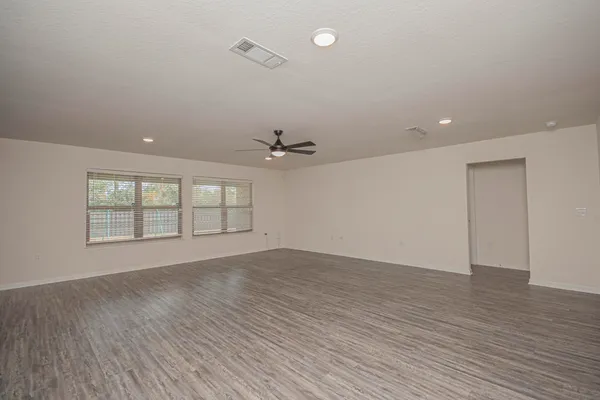 an empty room with a window and a ceiling fan
