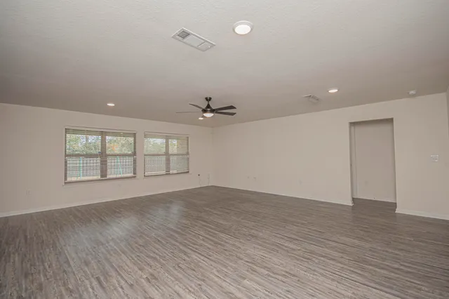 an empty room with a window and a ceiling fan