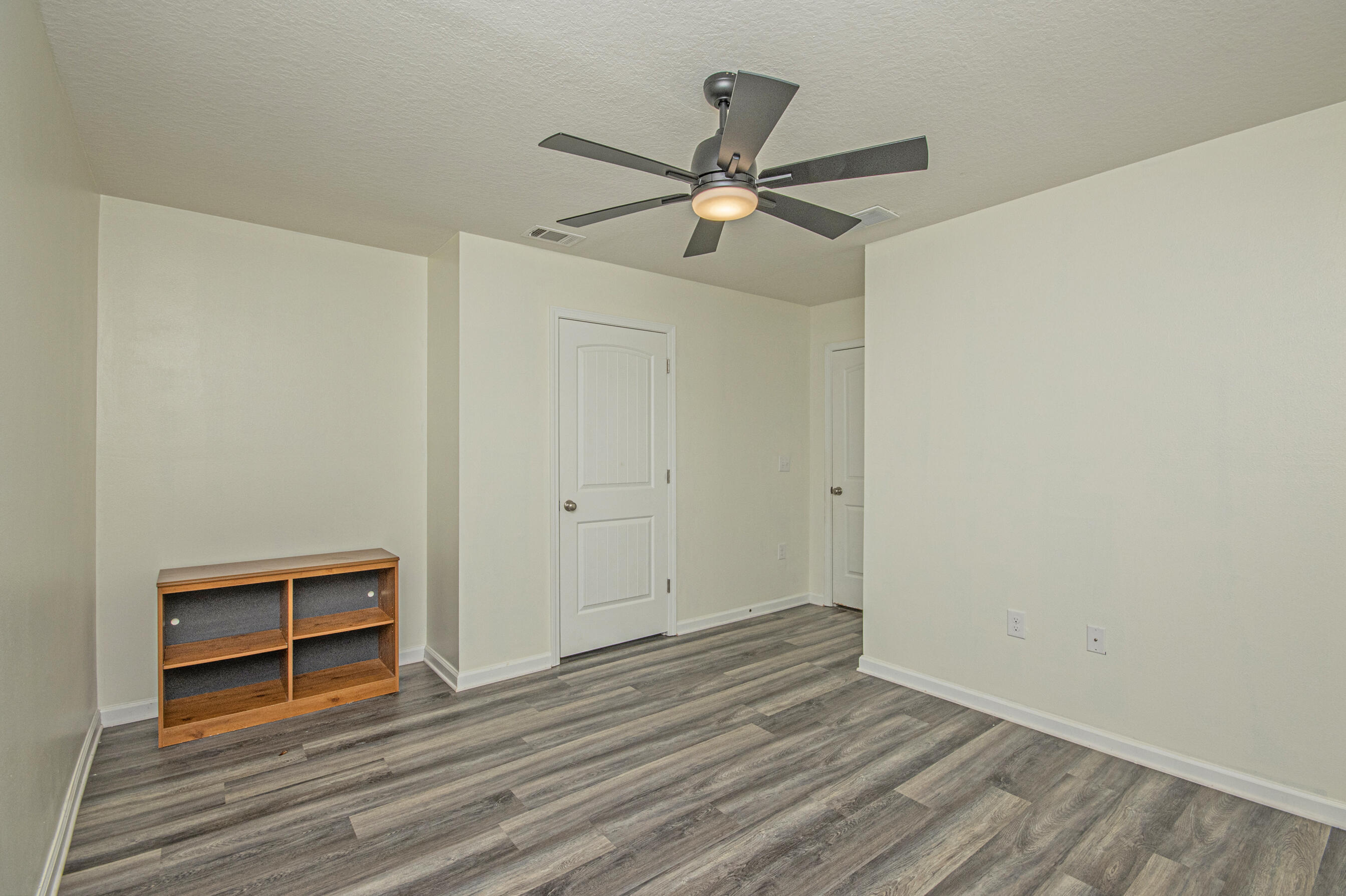 356 Merlin Court Crestview, FL 32539 - Photo 35 of 70 a view of empty room with wooden floor and fan