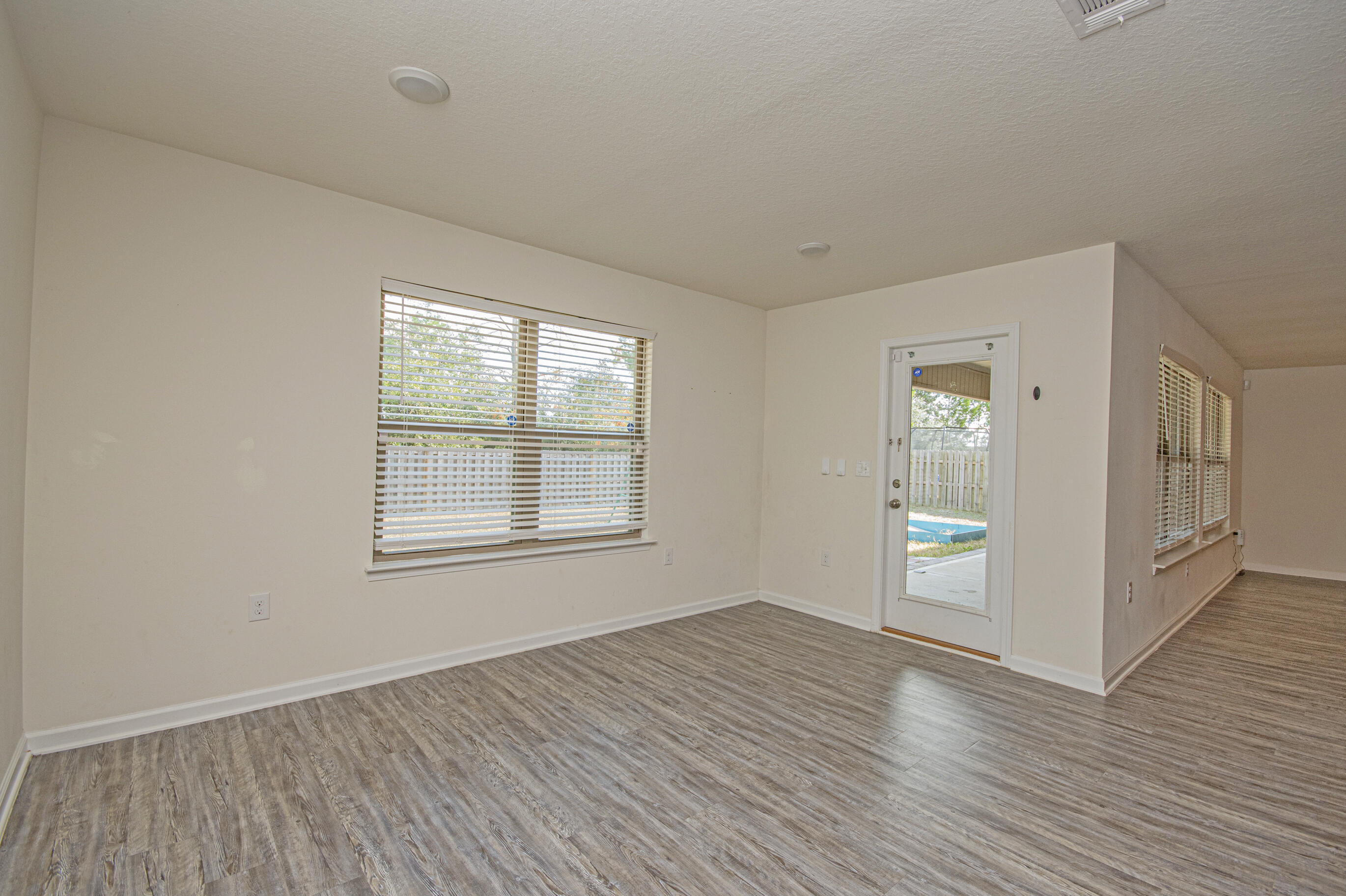 356 Merlin Court Crestview, FL 32539 - Photo 41 of 70 an empty room with wooden floor and windows