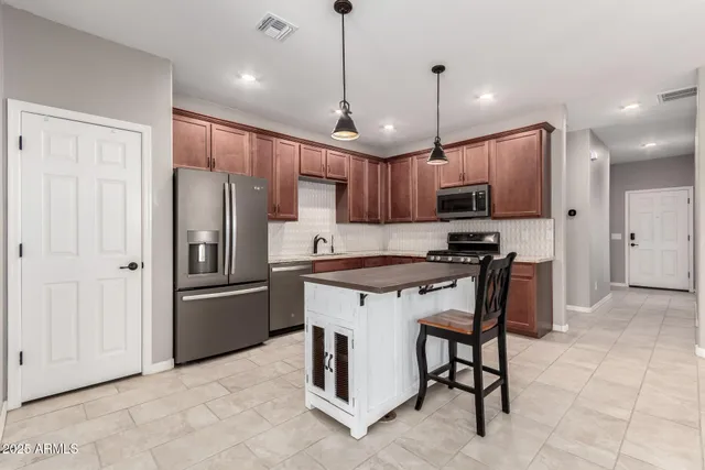 a kitchen with stainless steel appliances granite countertop a refrigerator a stove a sink and a oven