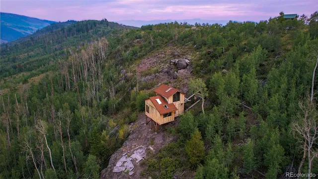 a aerial view of a house with a yard and mountain
