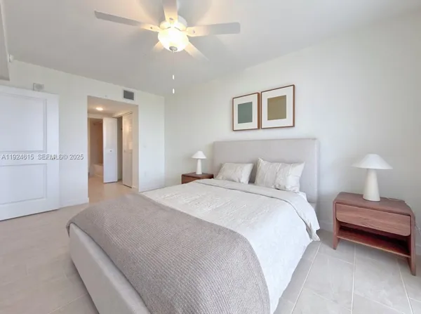 a bedroom with a large bed and a chandelier