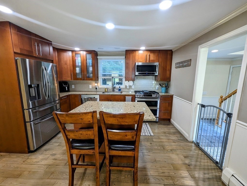 93 Blood Road Charlton, MA 01507 - Photo 23 of 42 a dining room with stainless steel appliances a dining table wooden floor and a refrigerator