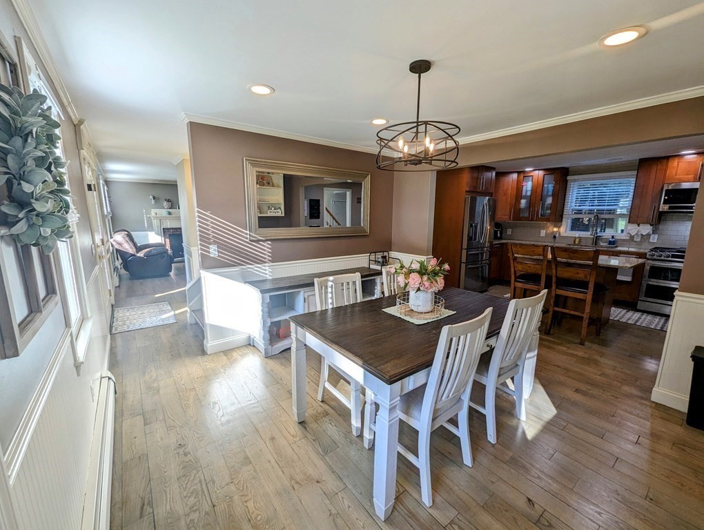 93 Blood Road Charlton, MA 01507 - Photo 8 of 42 a dining room with wooden floor a chandelier a wooden table and chairs