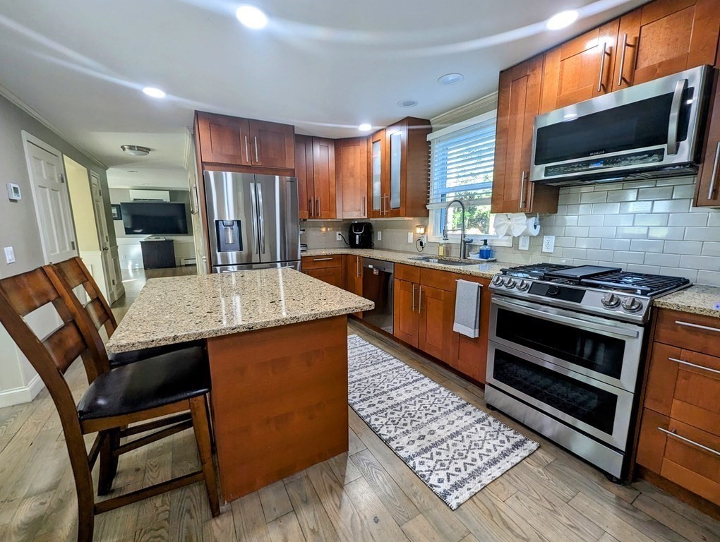 93 Blood Road Charlton, MA 01507 - Photo 9 of 42 a kitchen with stainless steel appliances kitchen island granite countertop a stove a sink dishwasher a microwave oven with granite countertops and cabinets