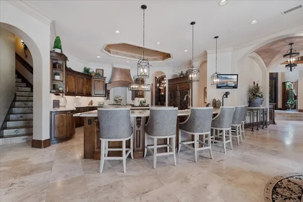 a dining room with stainless steel appliances kitchen island granite countertop a table chairs and a refrigerator
