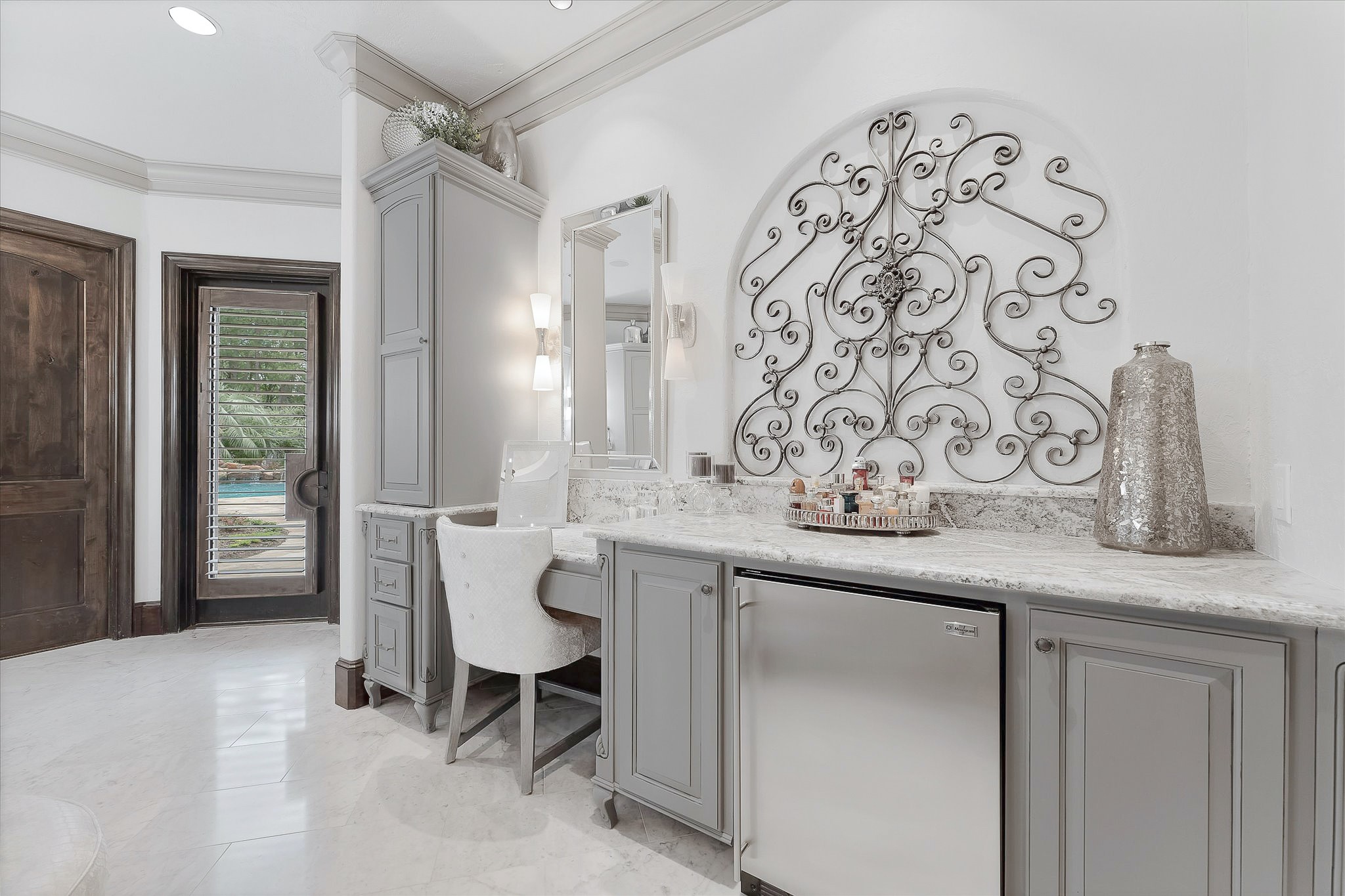 28322 Meadow Forest Magnolia, TX 77355 - Photo 22 of 50 The Walk-in Primary closet offers extensive built-in wardrobe storage, built-in display cabinets, countertops, closet bench, and designer carpet. A spacious extra room, opposite the primary closet, serves as a workout room with a built-in desk and cabinets and windows with custom wood shutters offering views of the backyard with southern and eastern exposures. This room can easily be converted into a second primary walk-in closet.