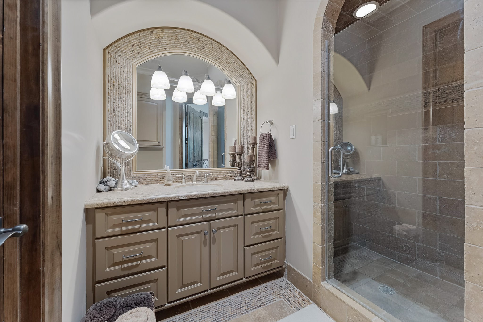 28322 Meadow Forest Magnolia, TX 77355 - Photo 32 of 50 Guest bedroom ensuite #1 on the second floor. Dual Adler wood doors lead to the Ensuite bathroom with custom tile flooring with intricate patterns, a shower with a built-in bench, and a Granite countertop vanity with Custom framed mirror. Walk-in Closet with built-in and door jamb Light Switch.