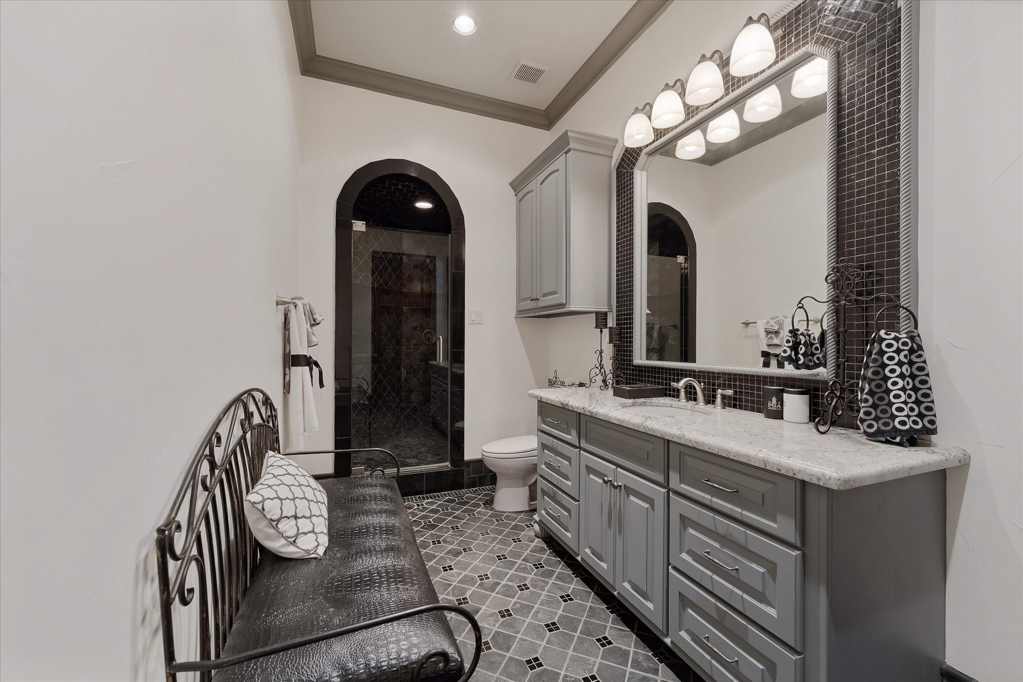 28322 Meadow Forest Magnolia, TX 77355 - Photo 36 of 50 Guest bedroom ensuite #3 on the second floor. Custom tile flooring with an intricate pattern, a shower with a built-in bench. Alpine granite countertop vanity with Custom framed mirror. Walk-in Closet With built-ins and a window providing northern exposures and views of the front yard, door Jamb Light Switch.