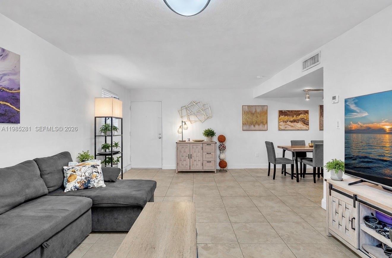 1236 Alton Road, Unit 304 Miami Beach, FL 33139 - Photo 6 of 28 a living room with furniture and a flat screen tv