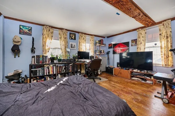 a bedroom with furniture and a flat screen tv