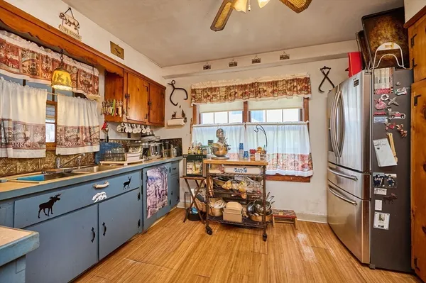 a kitchen with stainless steel appliances a refrigerator a sink and wooden cabinets