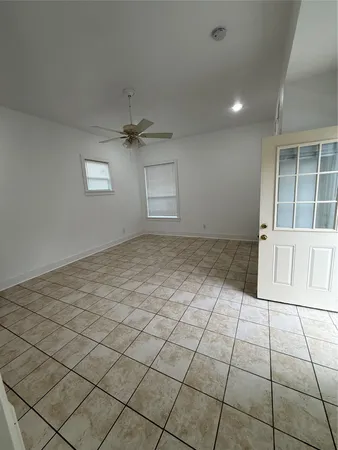 an empty room with windows and ceiling fan