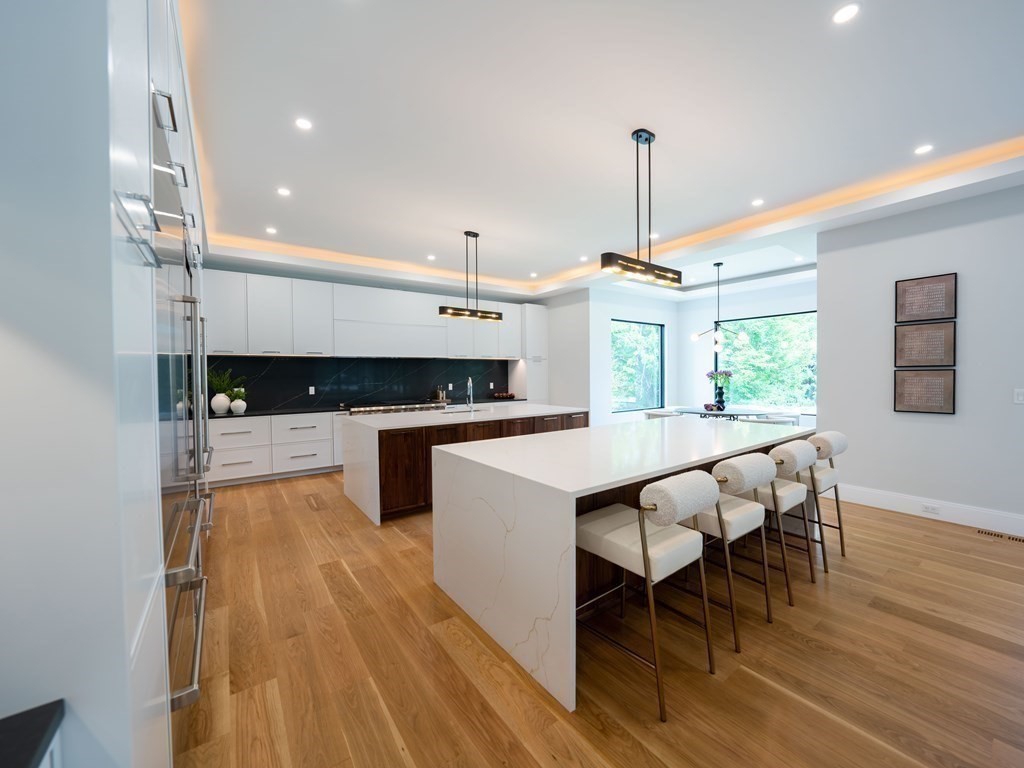 88 Levbert Road Newton, MA 02459 - Photo 7 of 41 a kitchen with stainless steel appliances kitchen island granite countertop a stove a sink and a wooden floors