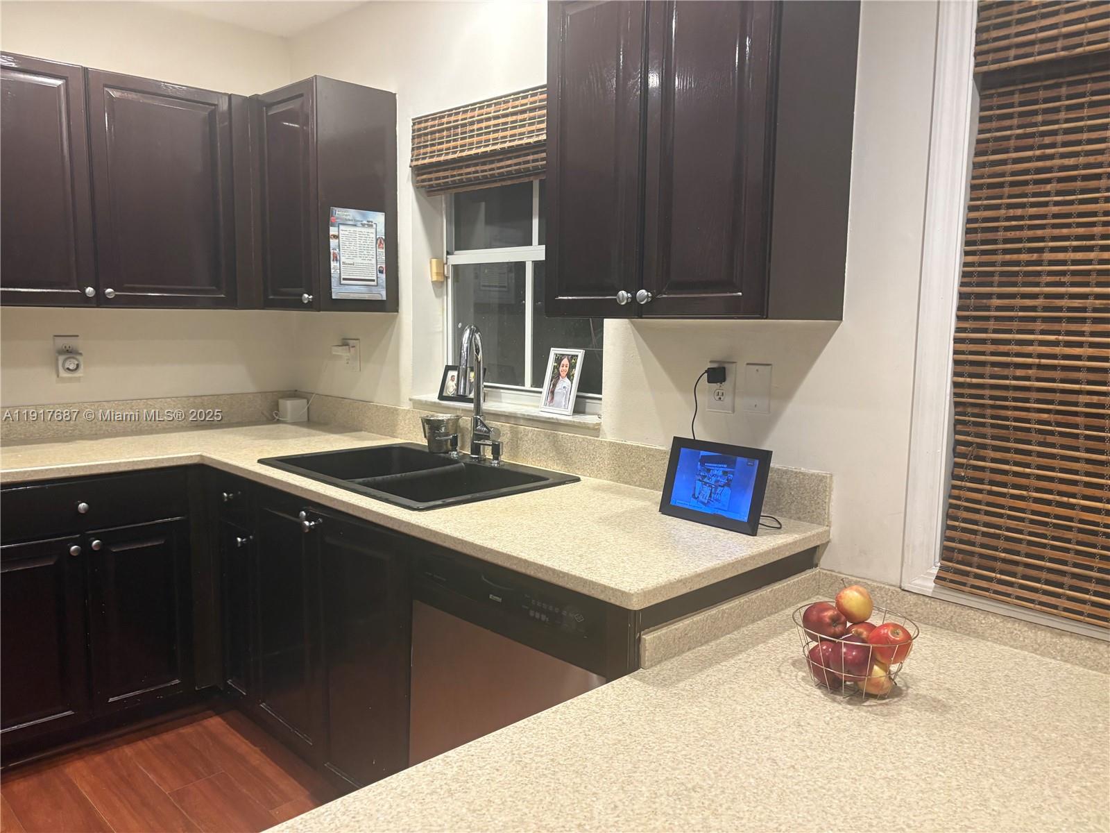 3195 North 36th Avenue Hollywood, FL 33021 - Photo 12 of 27 a kitchen with stainless steel appliances a sink dishwasher and a refrigerator with wooden cabinets
