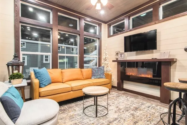 a living room with furniture a flat screen tv and a fireplace
