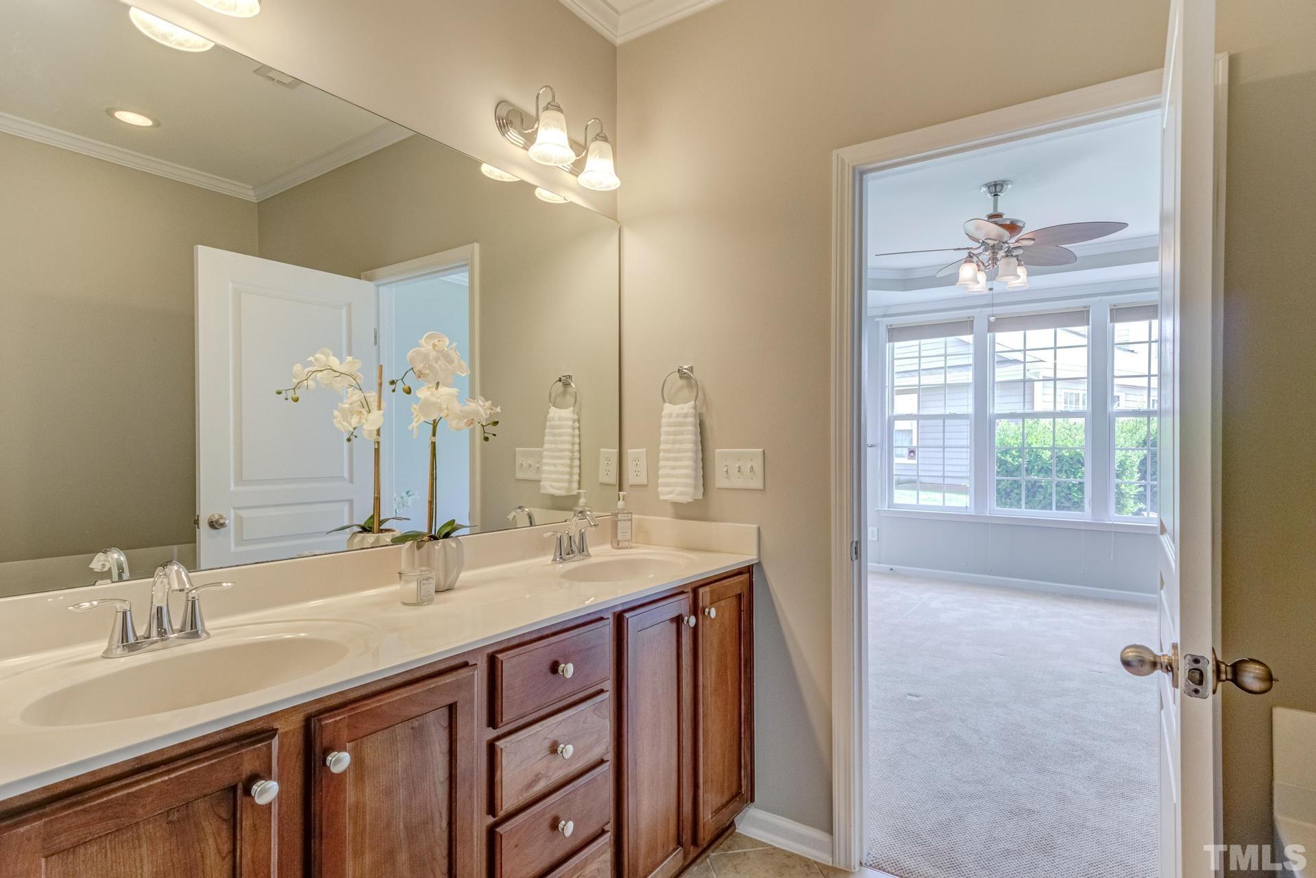 10114 Falls Meadow Court Raleigh, NC 27617 - Photo 32 of 53 a bathroom with a double vanity sink and a mirror