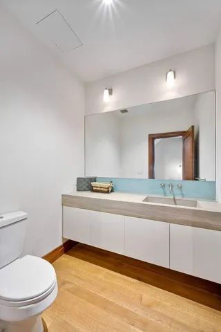 a bathroom with a toilet a sink and mirror