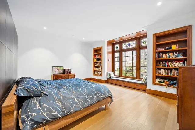 a bedroom with a large bed and a book shelf
