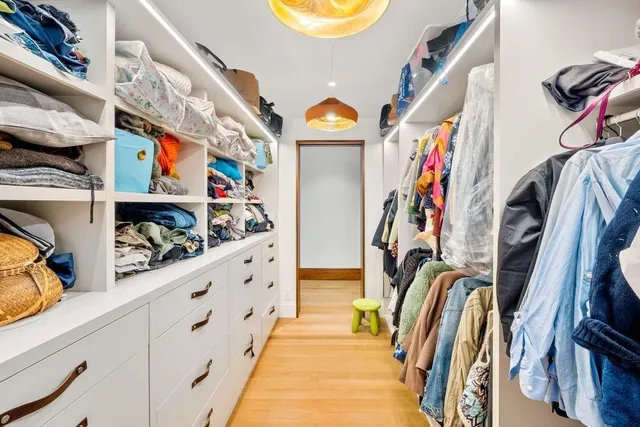 a view of walk in closet with clothes and shoes