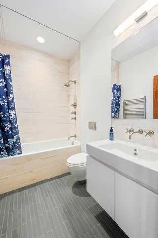 a bathroom with a double vanity sink toilet mirror and bathtub