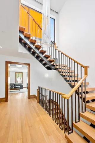 a view of staircase with railing and a large window