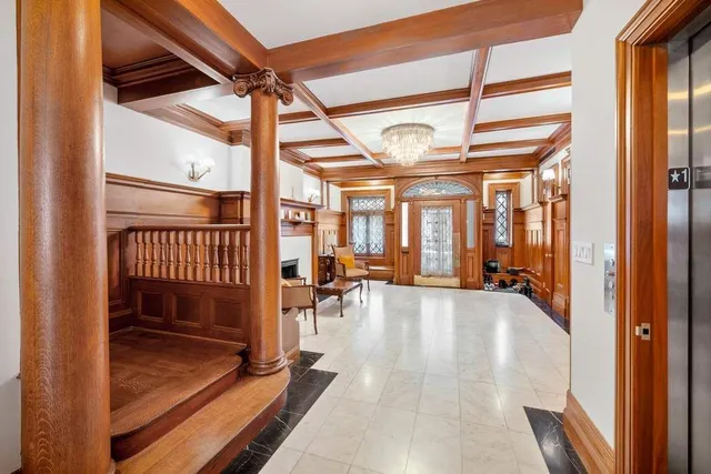 a front view of a building with lot of cars and trees