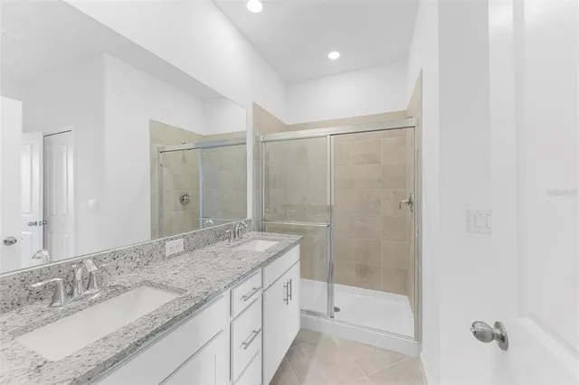 a bathroom with a granite countertop sink mirror and shower