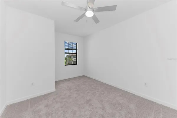 an empty room with closet and a chandelier fan