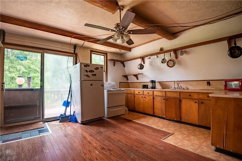 2738 Valley Road Mercer, PA 16137 - Photo 8 of 27 a kitchen with stainless steel appliances granite countertop a refrigerator a sink dishwasher a stove and a refrigerator with wooden floor