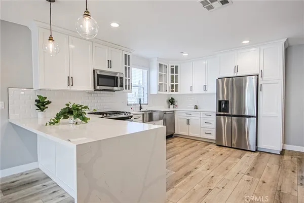 a kitchen with a white wooden cabinets and white appliances