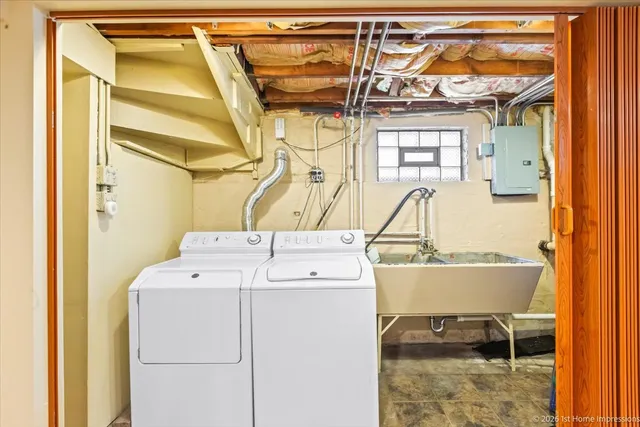 a front view of a house with a yard and large tree