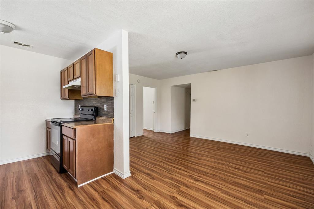 6221 Pine Street Rowlett, TX 75089 - Photo 5 of 12 Kitchenette with wood-finish cabinetry, dark countertop, and a tiled backsplash