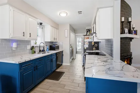 a kitchen with granite countertop a sink stove and cabinets