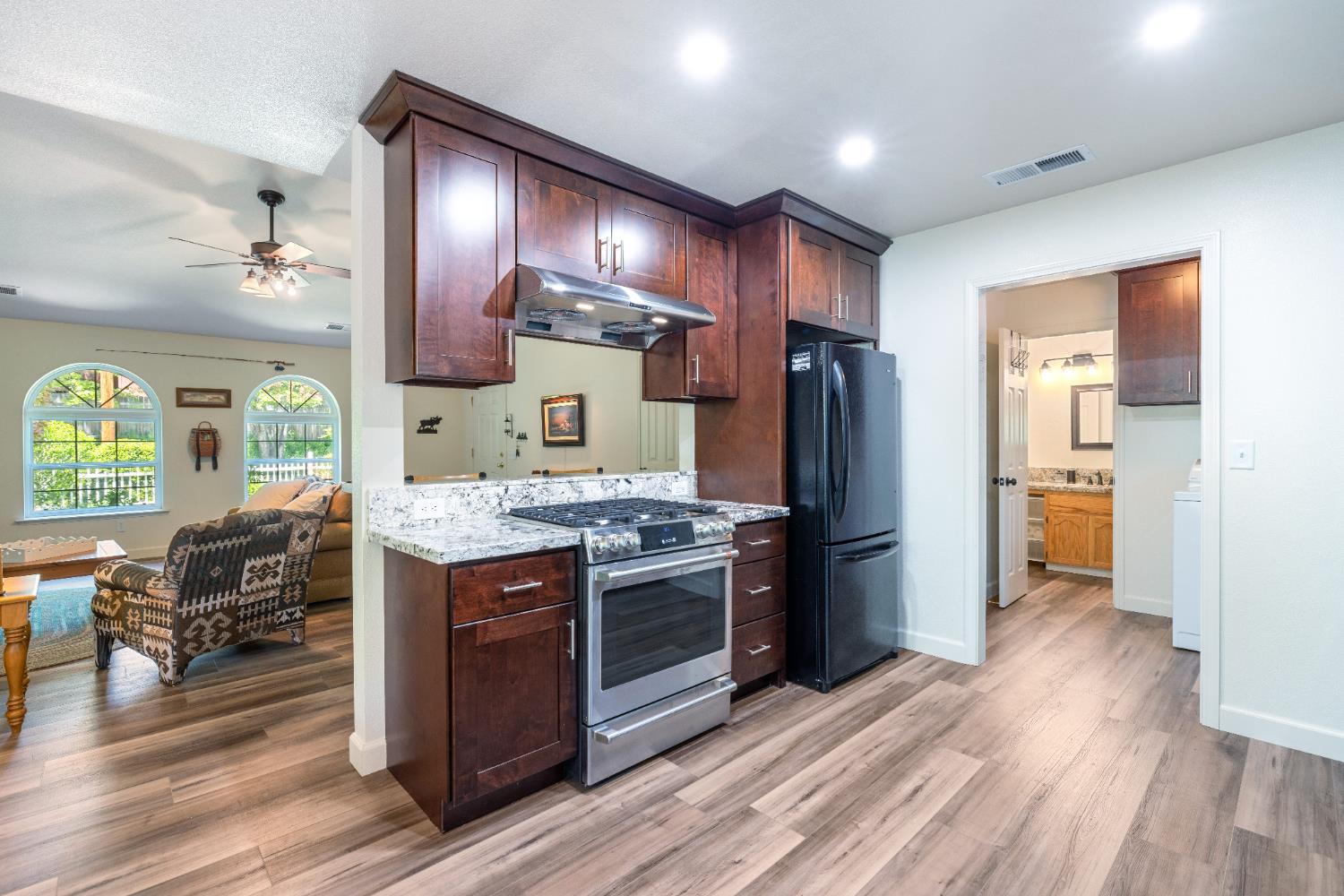 39398 Robin Bass Lake, CA 93604 - Photo 11 of 31 a kitchen with stainless steel appliances granite countertop a stove refrigerator and wooden floor