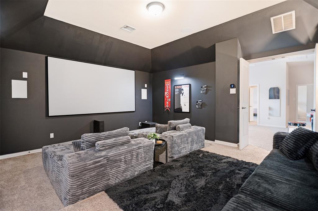 413 Frontier Court Midlothian, TX 76065 - Photo 14 of 26 Dedicated media room featuring a large projection screen, dark wall finishes, and recessed lighting