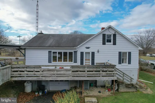 a view of a house with wooden deck stairs and backyard