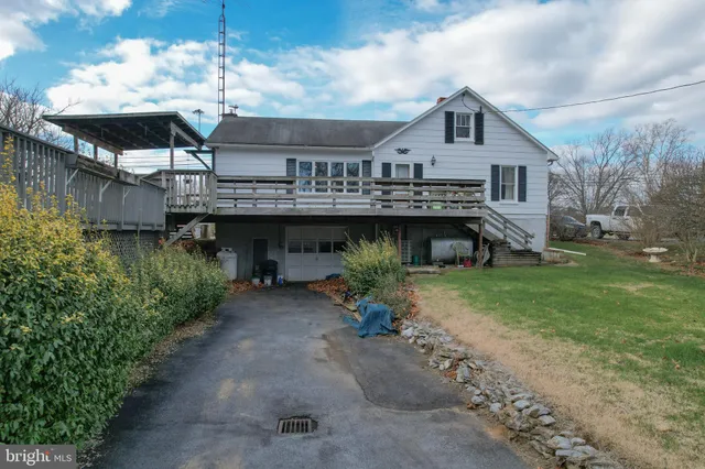 a view of a house next to a yard with plants and trees