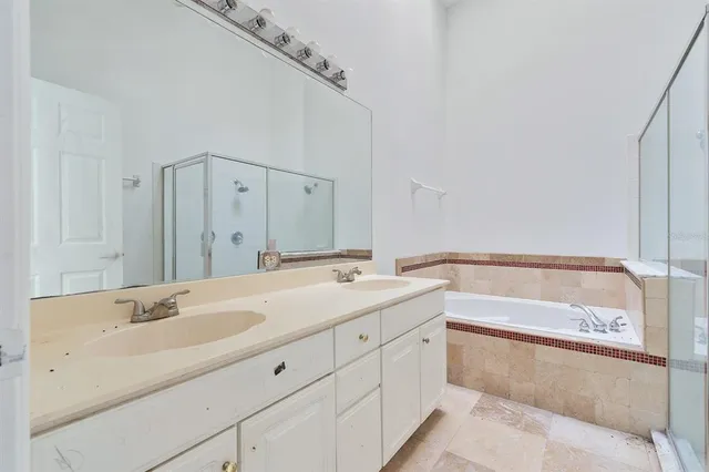 a bathroom with a tub sink and mirror