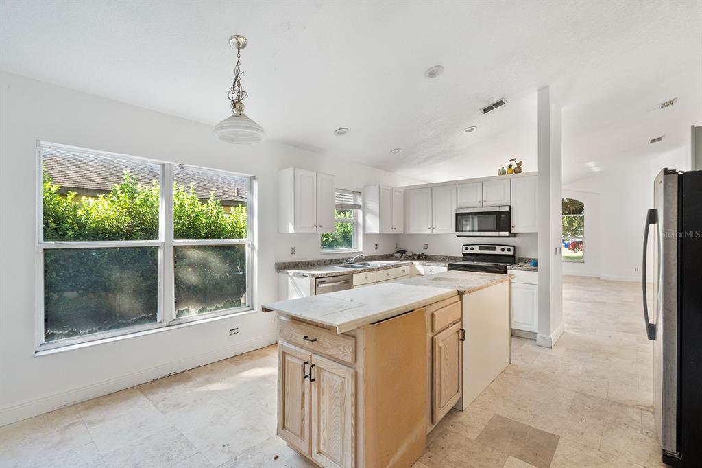 608 Bridge Creek Boulevard Ocoee, FL 34761 - Photo 8 of 17 a kitchen with kitchen island white cabinets and refrigerator